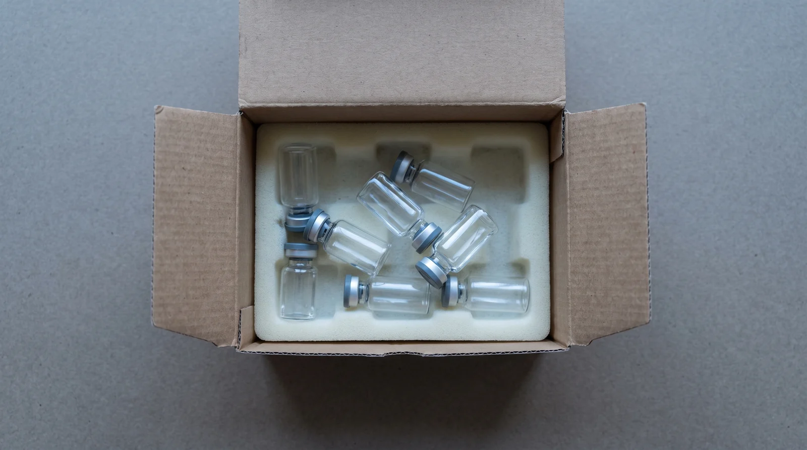 Unlabelled glass vials in a shipping tray, no markings or documentation.